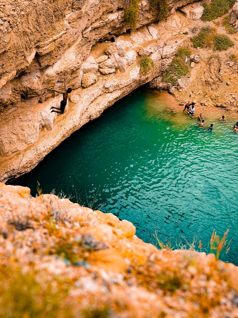 Saut dans une vasque d'eau émeraude entourée de rochers, ambiance randonnée aquatique du Bas-Chassezac