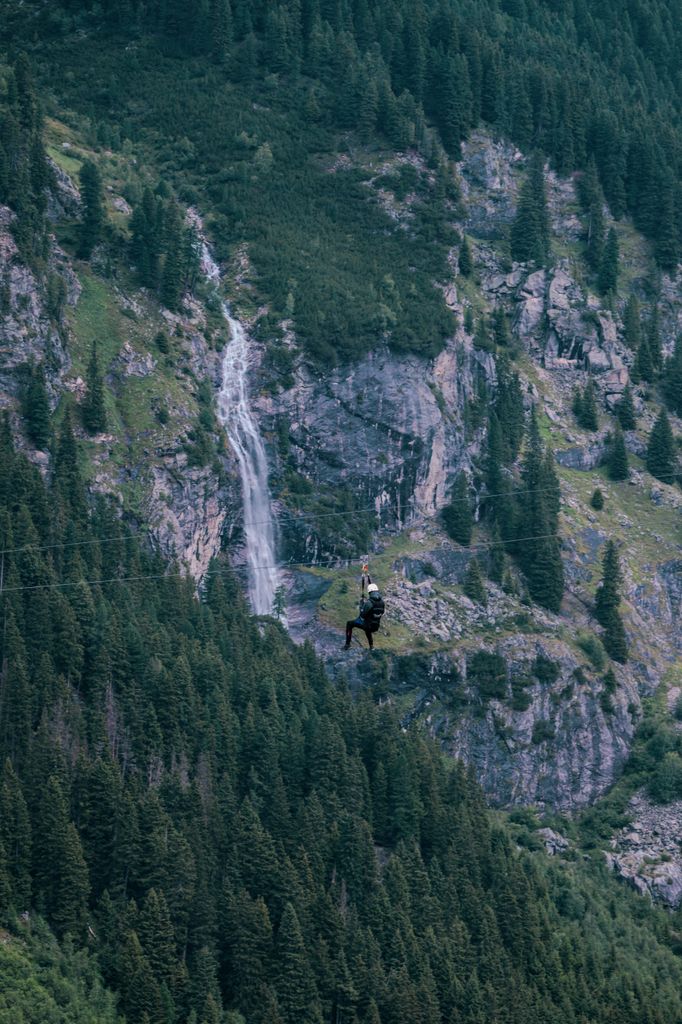 Tyrolienne géante au-dessus d'une rivière encaissée dans les gorges, ambiance de la via ferrata du Pont du Diable en Ardèche