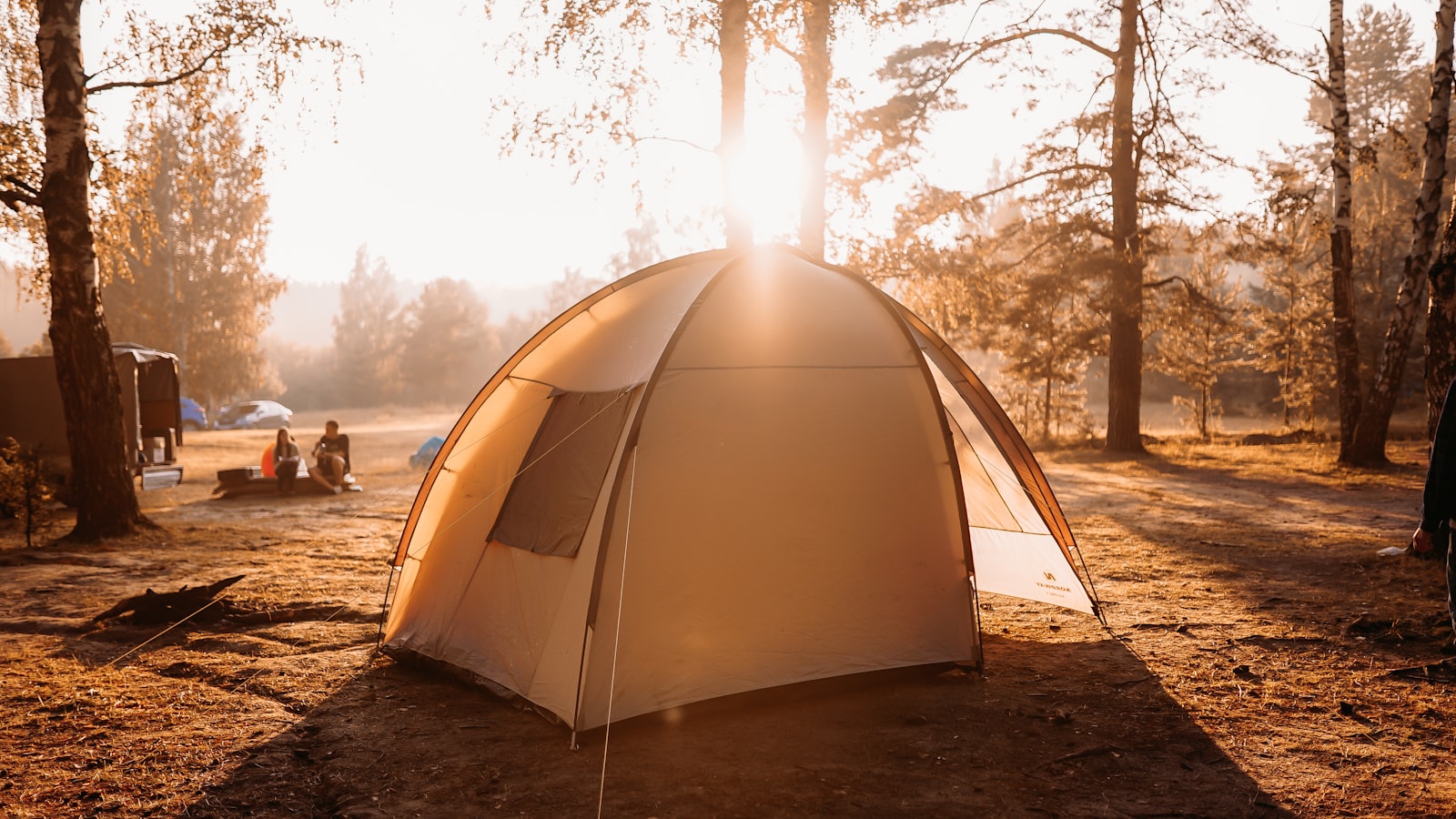 Tente dôme blanche installée sur un terrain de camping familial