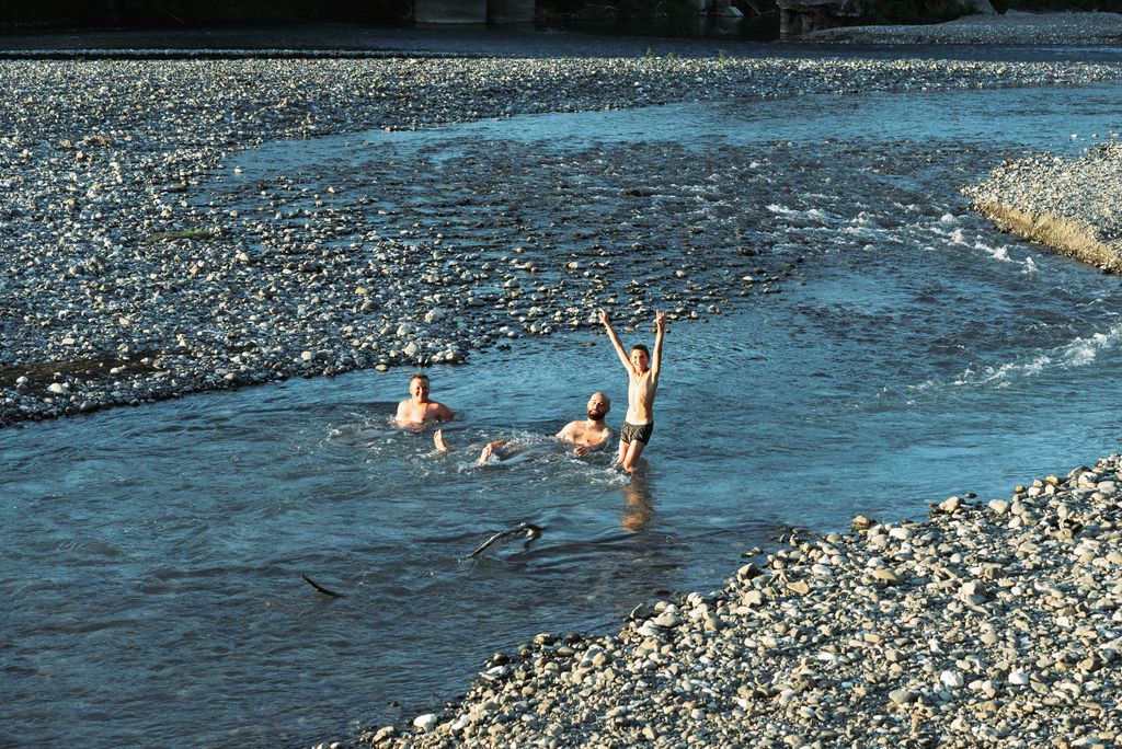 Baignade en famille sur la plage de galets de la rivière Beaume à Labeaume
