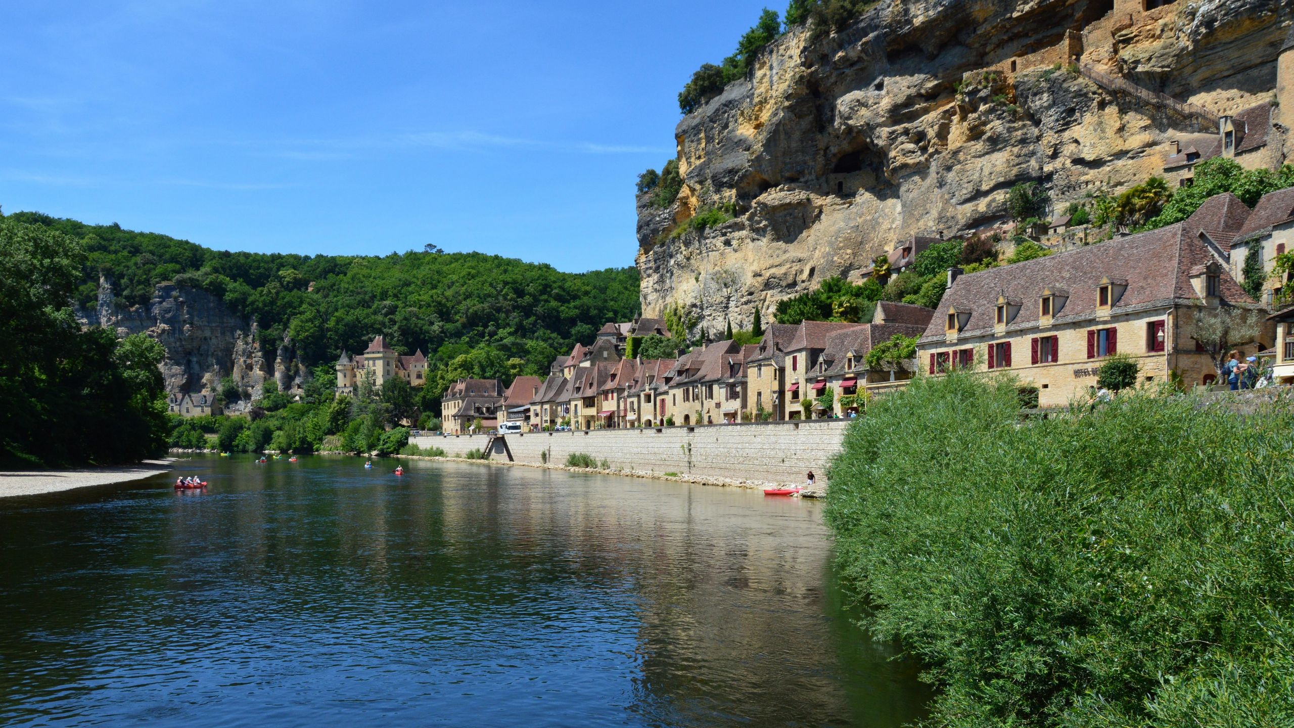 Village de pierre blotti au pied d'une falaise calcaire au bord de la riviere, comme Labeaume en Ardeche du Sud